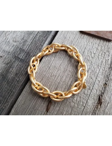 Gliederarmband glänzend goldfarben auf Holzuntergrund