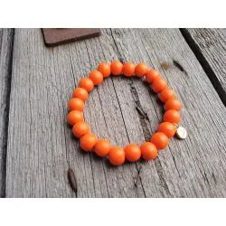 Armband aus Holzperlen in orange auf Holzuntergrund