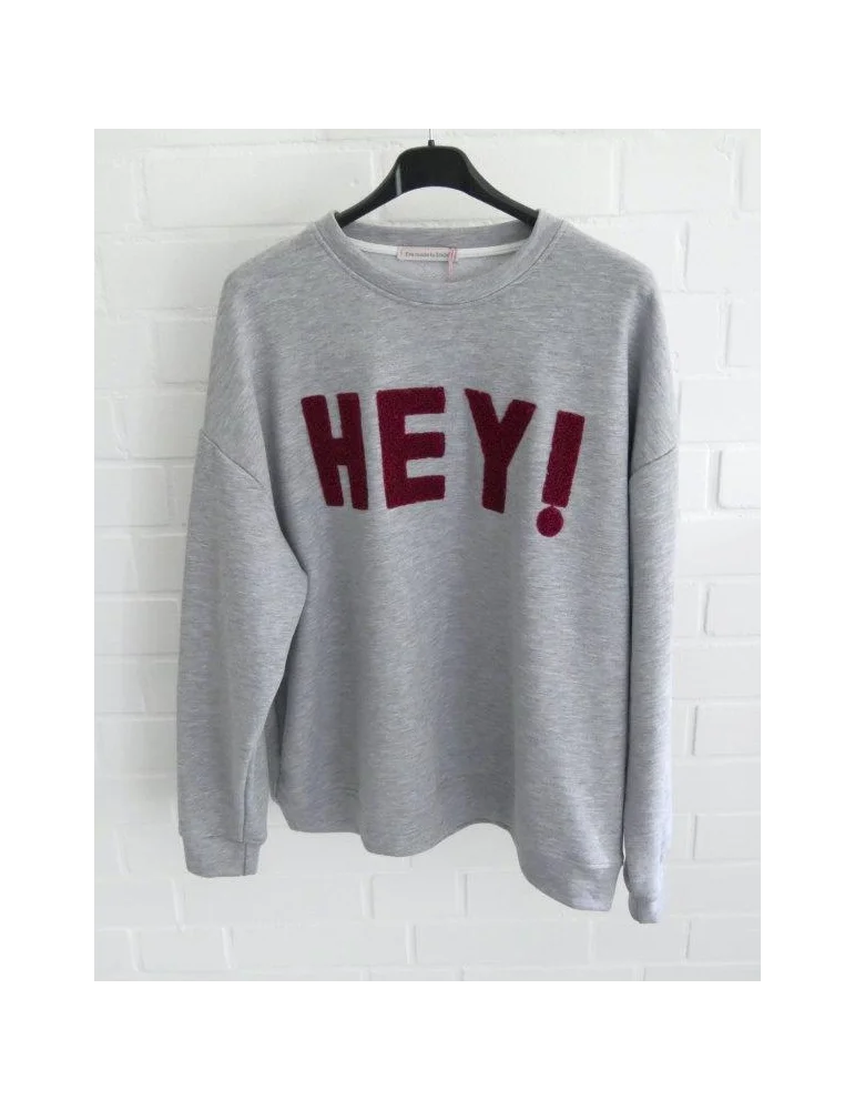 Graues Sweatshirt mit rotem HEY! Schriftzug auf der Vorderseite