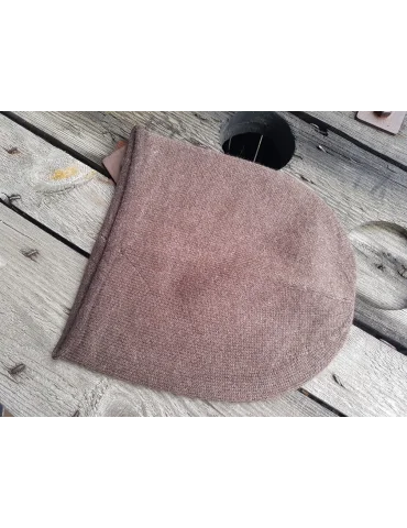 Weiche braune Mütze aus Strickstoff auf Holzhintergrund