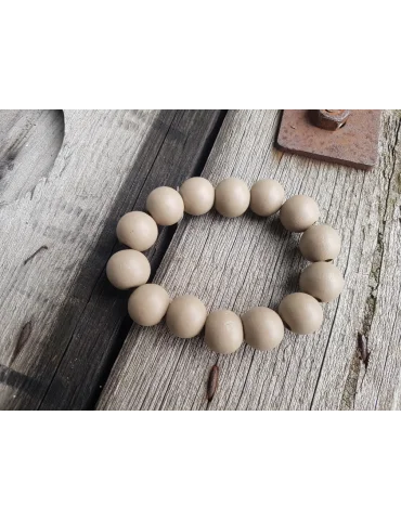 Armband mit Holzperlen in taupefarben auf einem Holzuntergrund