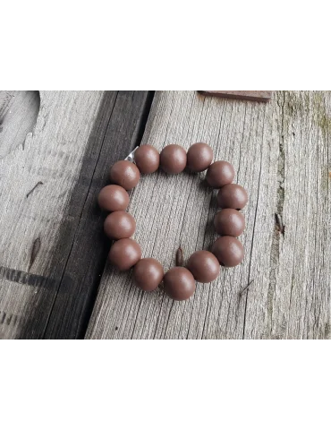 Armband mit Holzperlen in braun auf einem Holzuntergrund