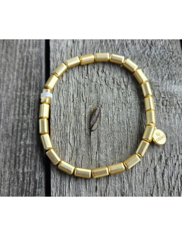 Damen Armband in mattem goldfarben aus aufgereihten Röhrchen auf Holzuntergrund
