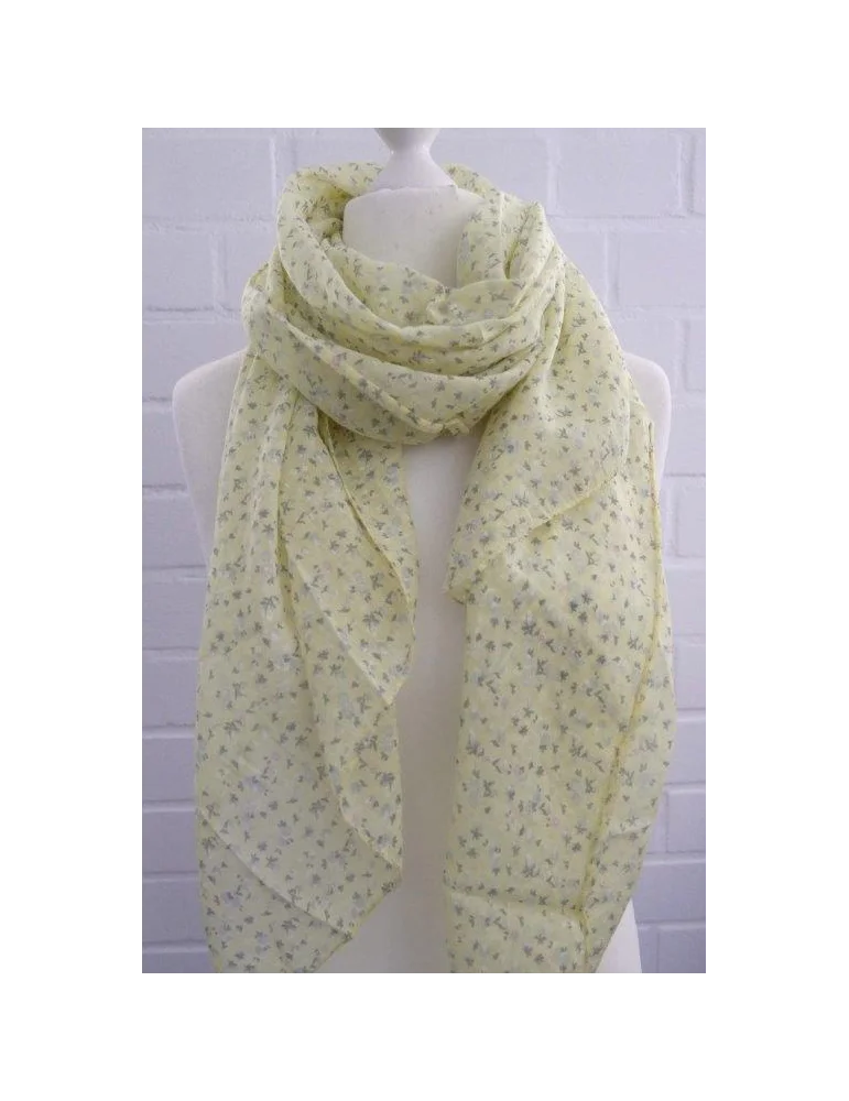 Hellgelber Schal mit bunten Streublumen vor weißer Wand