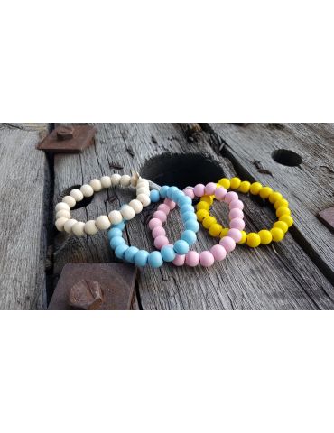 Viele bunte Holzperlenarmbänder auf einem Holzuntergrund