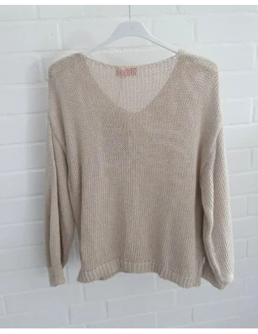 Rückansicht Beige gestrickter Damenpullover mit V-Ausschnitt auf Kleiderbügel vor weißer Wand