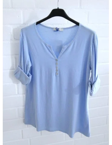 Hellblaues Damen-Shirt mit Henley-Ausschnitt und Turn-up Ärmeln auf einem Bügel