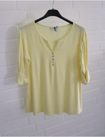 Gelbes Damen-Shirt mit Henley-Ausschnitt und Turn-up Ärmeln auf einem Bügel