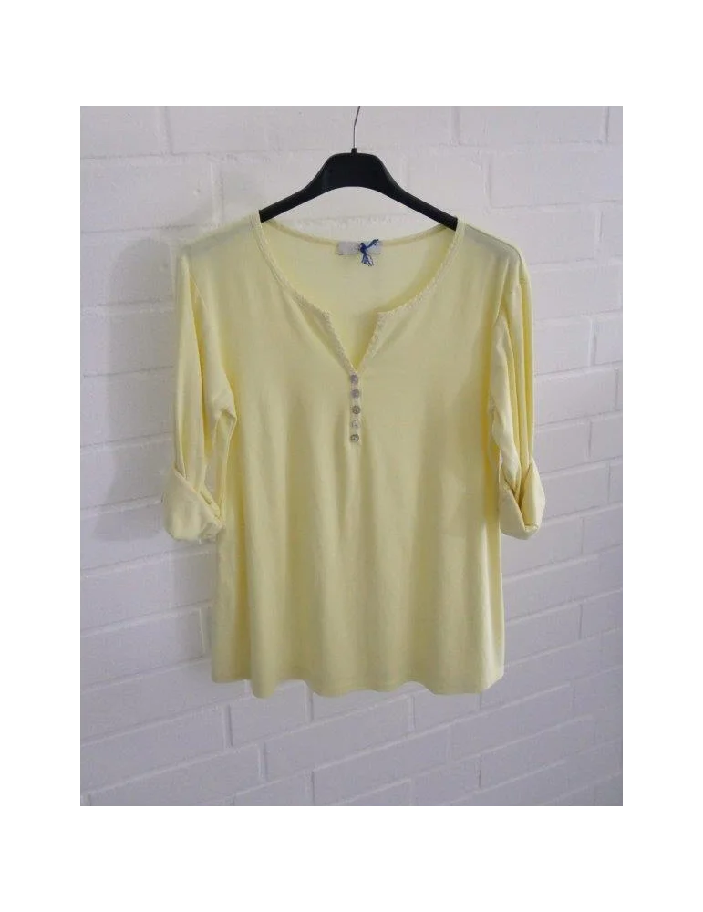 Gelbes Damen-Shirt mit Henley-Ausschnitt und Turn-up Ärmeln auf einem Bügel