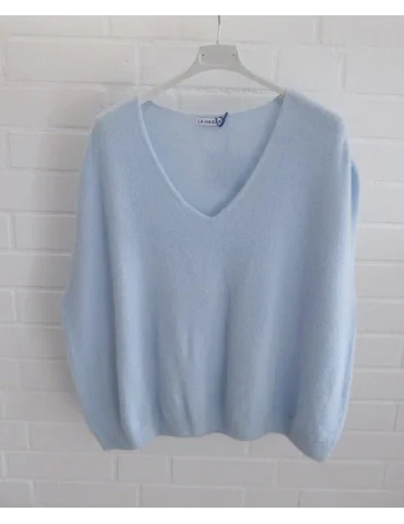 Hellblauer Pullunder mit V-Ausschnitt vor weißer Wand