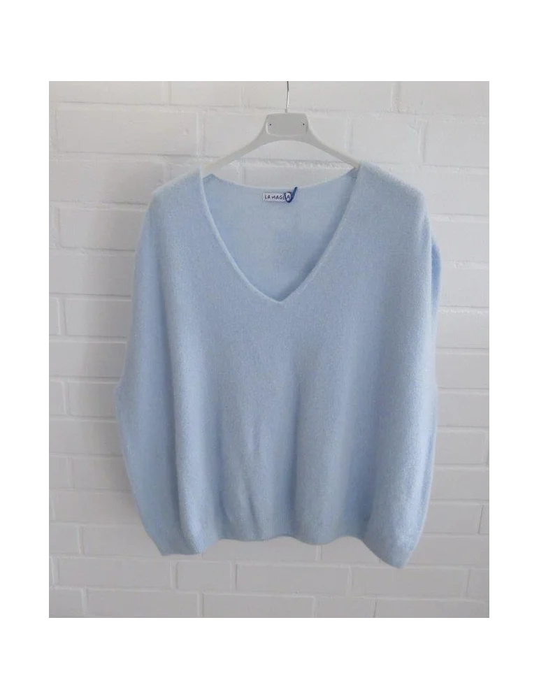 Hellblauer Pullunder mit V-Ausschnitt vor weißer Wand