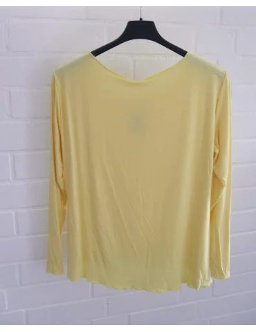 Rückansicht Gelbes langarm Shirt mit Rundhalsausschnitt vor weißer Wand