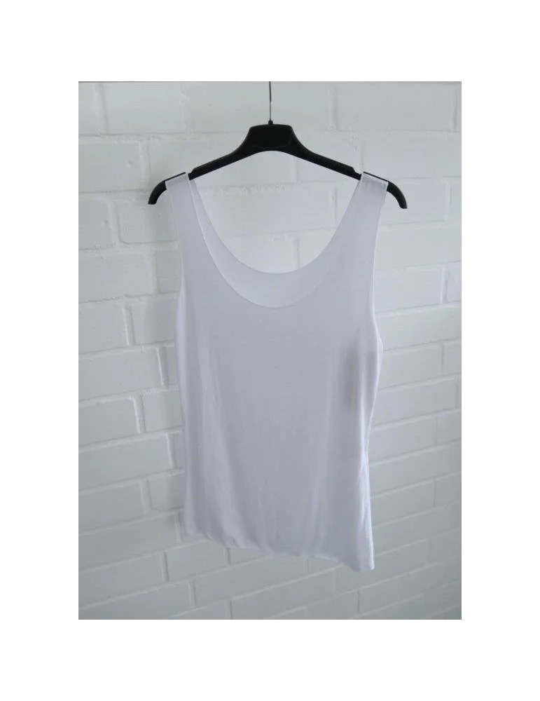 Weißes Damentop schlichte Art vor weißer Wand