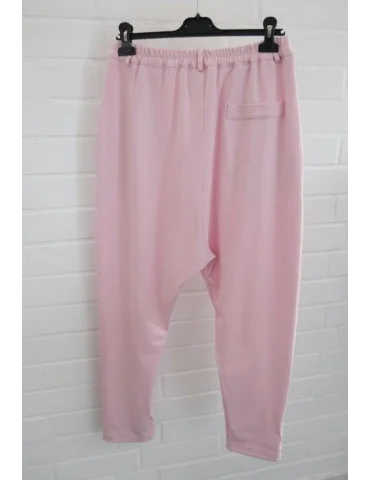 Rückansicht Rosefarbene Baggyhose mit weitem Bein vor Weißer Wand