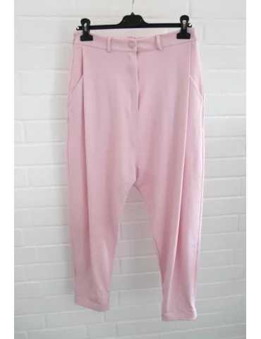 Rosefarbene Baggyhose mit weitem Bein vor Weißer Wand