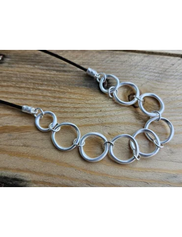 Kurze Modescmuckkette für Damen mit schwarzem Textilband und eingearbeiteten silberfarben, matten Ringen