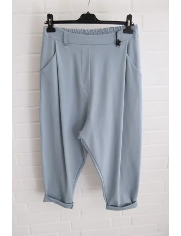 Jeansblaue Baggyhose mit Gürtelschlaufen vor weißer Wand