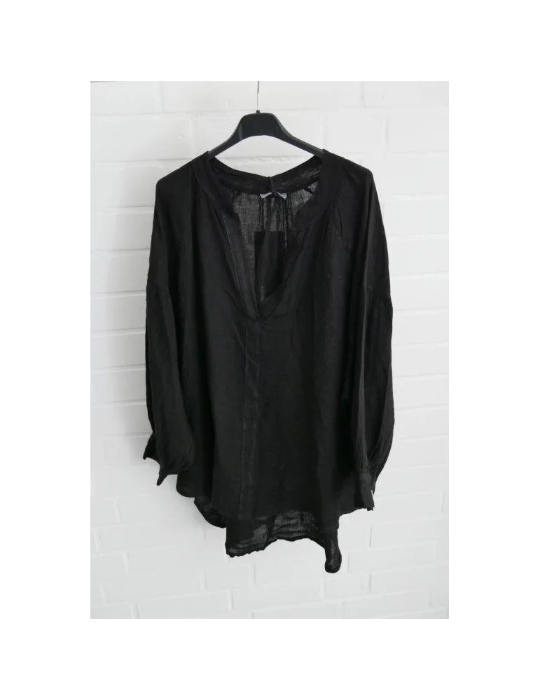 Schwarze Leinenbluse für Damen mit Ballonärmeln vor weißer Wand