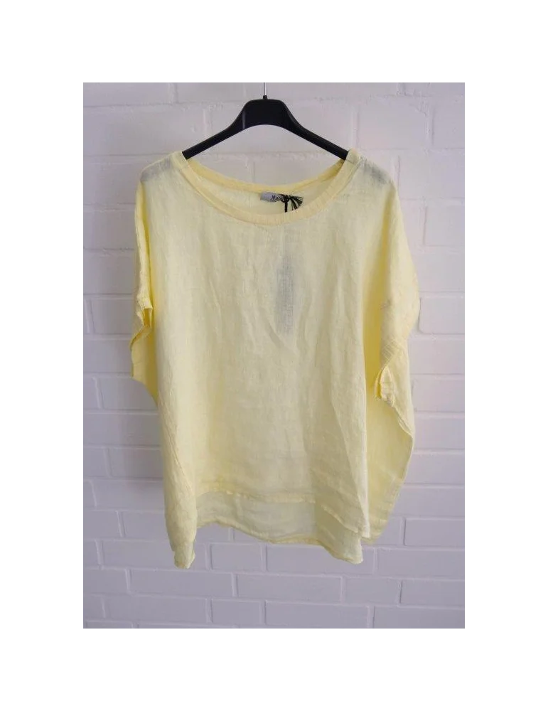 Gelbes Leinen T-Shirt mit Ziernähten vor weißer Wand