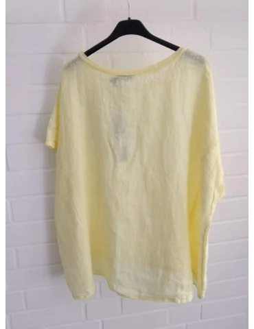 Rückansicht Gelbes Leinen T-Shirt mit Ziernähten vor weißer Wand