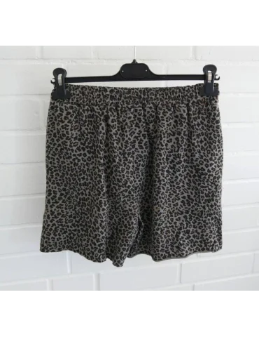 Rückansicht Graue Damen Shorts mit dunklem Leopardenmuster und elastischem Bund vor weißer Ziegelwand