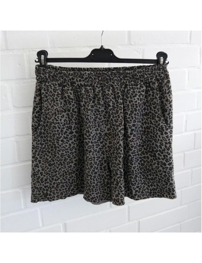 Graue Damen Shorts mit dunklem Leopardenmuster und elastischem Bund vor weißer Ziegelwand