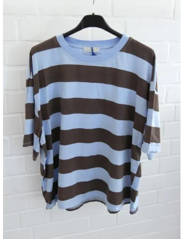 Hellblau und braun gestreiftes Damen Oversized T-Shirt hängend vor weißer Ziegelwand