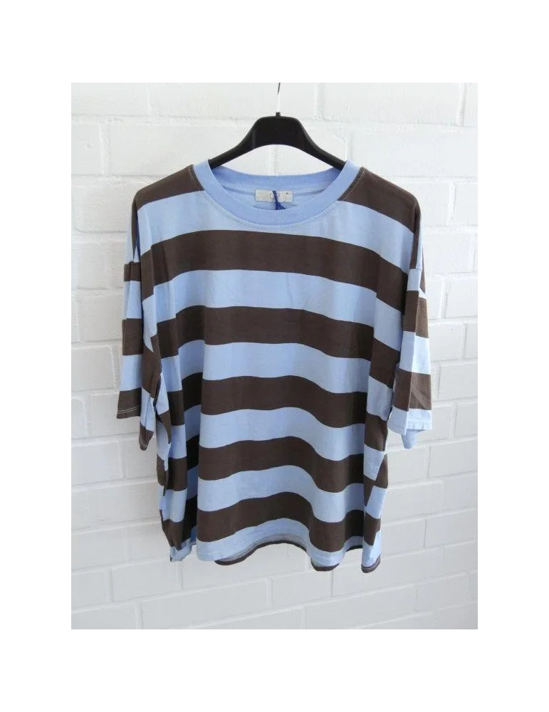 Hellblau und braun gestreiftes Damen Oversized T-Shirt hängend vor weißer Ziegelwand