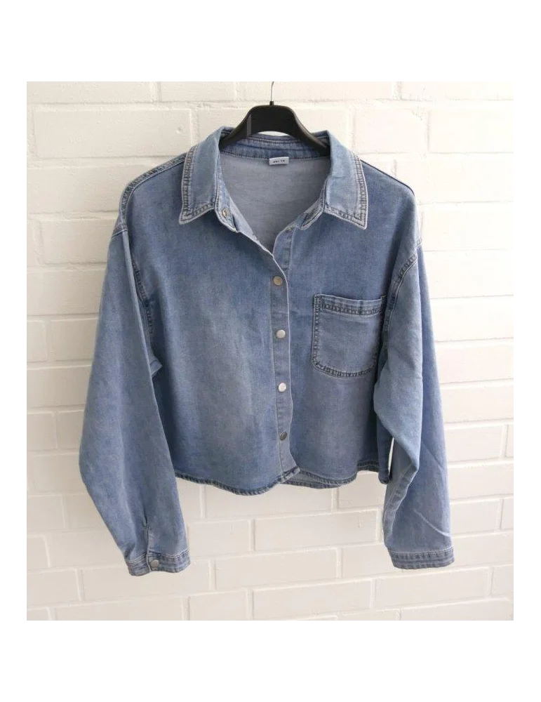 Kurzes kastiges Jeanshemd für Damen vor weißer Wand