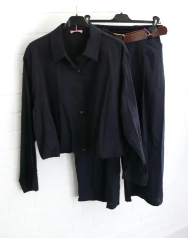 Kombination aus dunkelblauer Bluse und Culotte Hose vor weißer Wand