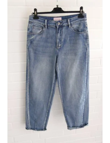 Hellblaue Damen Jeans im Mom-Fit locker hochgekrempelt mit weißen Sneakern kombiniert