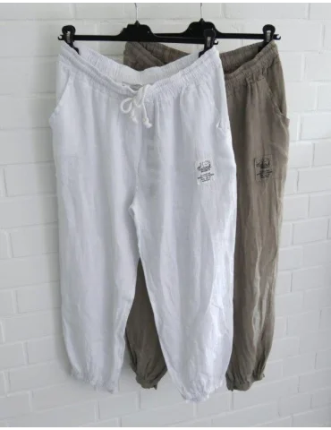 Zwei Leinenhosen in weiß und beige vor weißer Wand