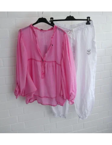 Kombination aus weißer Leinenhose und pinker Fledermausärmelbluse