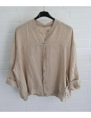 Beiger Damen Blusen-Blouson aus 100% Leinen auf schwarzem Kleiderbügel vor weißer Wand