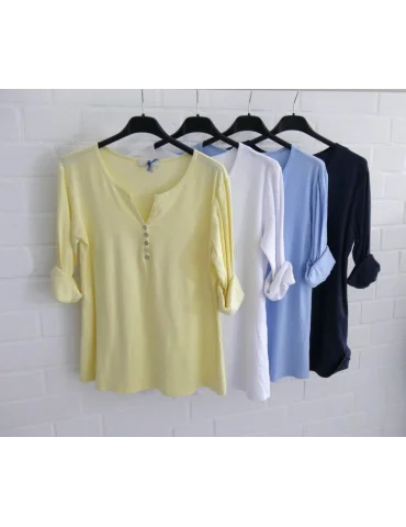 Vier Shirts auf Bügel vor weißer Wand