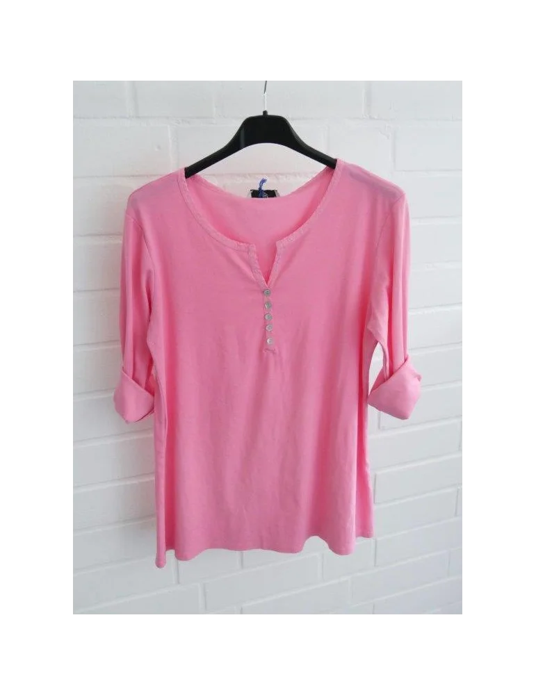 Pinkes Shirt mit Knopfleiste und langen Ärmeln vor weißer Wand