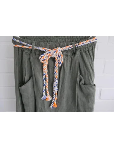 Nahaufnahme Gürtel der Olive Damen Leinenhose im Baggy-Schnitt mit buntem Kordelgürtel auf Kleiderbügel vor weißer Wand