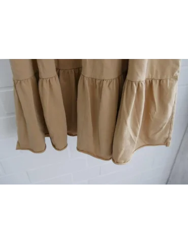 Nahaufnahme Saum des Langes, camelbraunes Sommerkleid mit schmalen Spaghettiträgern und Volantsaum