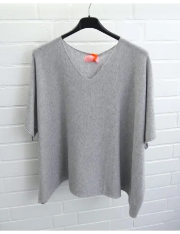 Hellgraues Oversize-Shirt mit V-Ausschnitt und weitem Schnitt auf einem Kleiderbügel