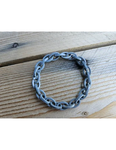 Graues Gliederarmband aus Kunststoff auf Holzuntergrund