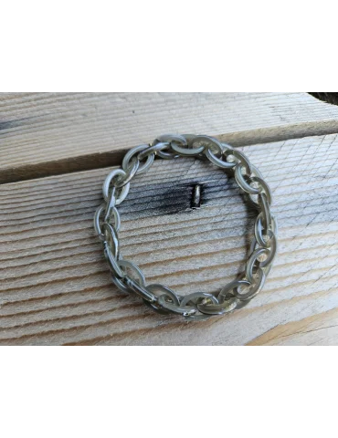 Olivgrünes Glieerarmband aus Kunststoff auf Holzuntergrund