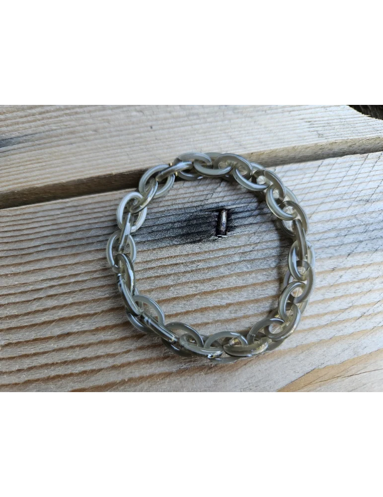 Olivgrünes Glieerarmband aus Kunststoff auf Holzuntergrund