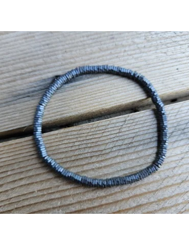 Anthrazitfarbenes Armband aus kleinen Metallplättchen auf Holzuntergrund