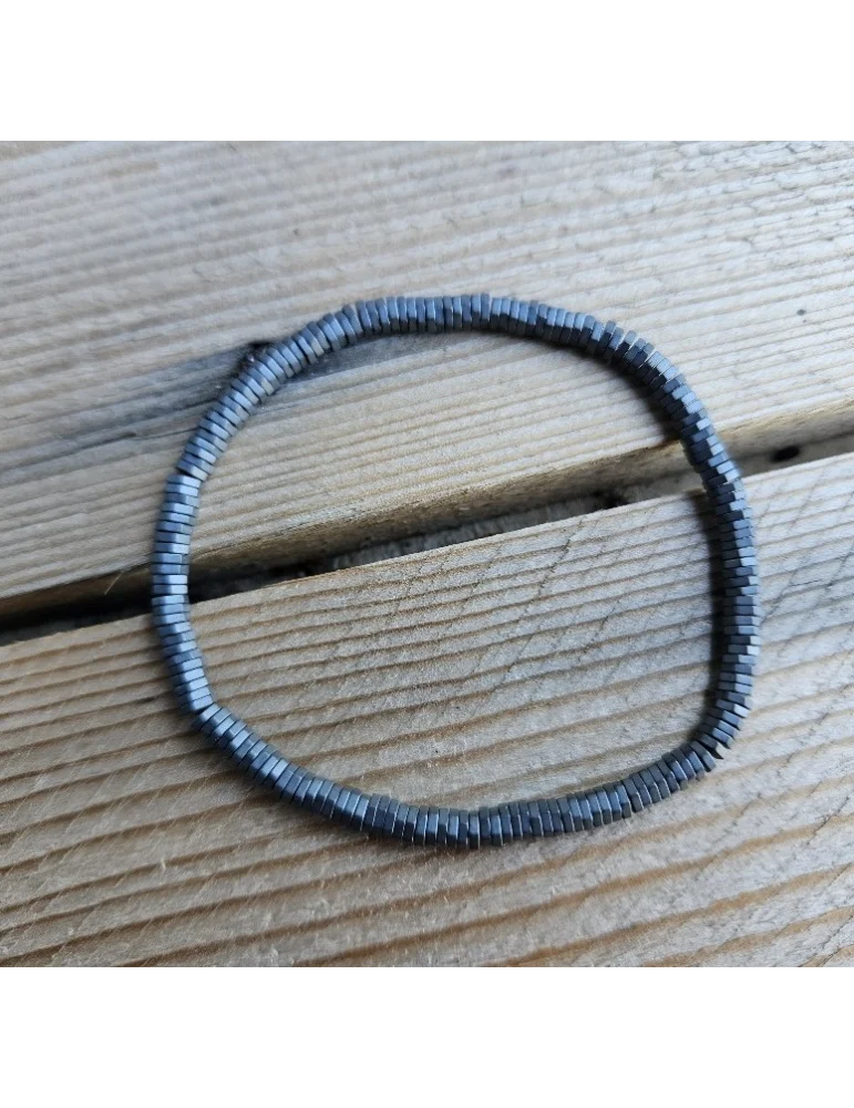 Anthrazitfarbenes Armband aus kleinen Metallplättchen auf Holzuntergrund