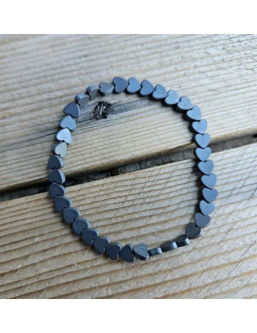 Anthrazitfarbenes Armband mit kleinen Herzelementen auf Holzuntergrund
