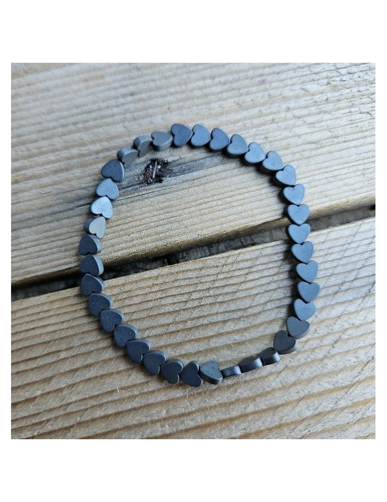 Anthrazitfarbenes Armband mit kleinen Herzelementen auf Holzuntergrund