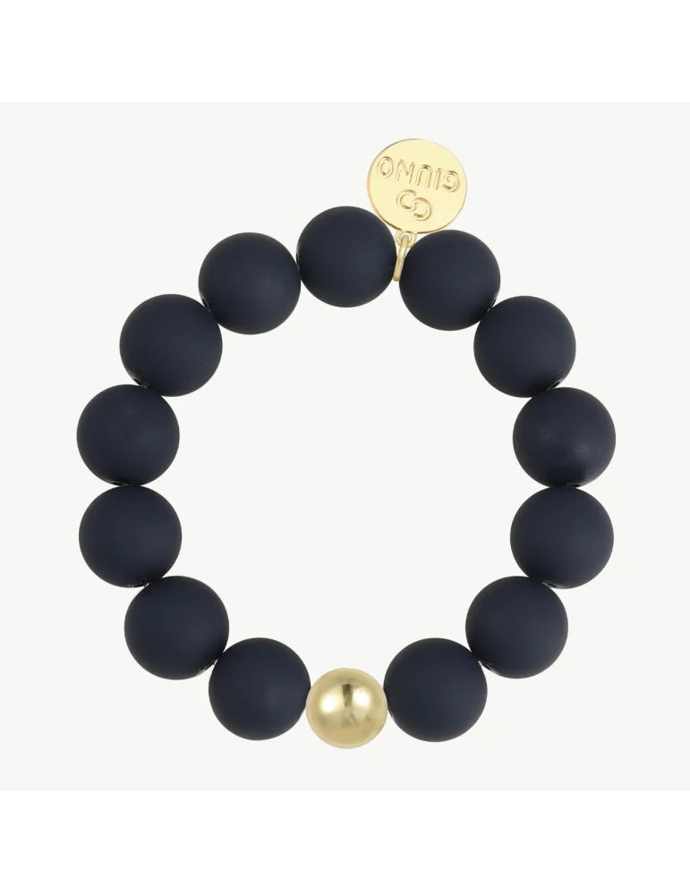 Armband mit matt schwarzen Perlen und einer goldfarbenen Perle auf weißem Untergrund