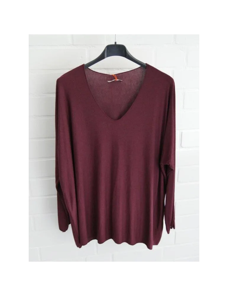 Weinrotes Shirt mit V-Ausschnitt für Damen vor weißer Wand
