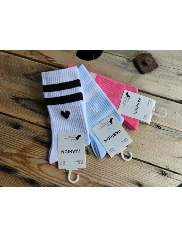 Mehrere Socken mit Streifen und Herzen auf Holzuntergrund
