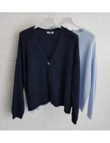 Hellblaue und dunkelblaue Damenstrickjacken mit V-Ausschnitt vor weißer Wand